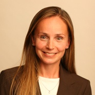 a woman with long blonde hair wearing a brown blazer