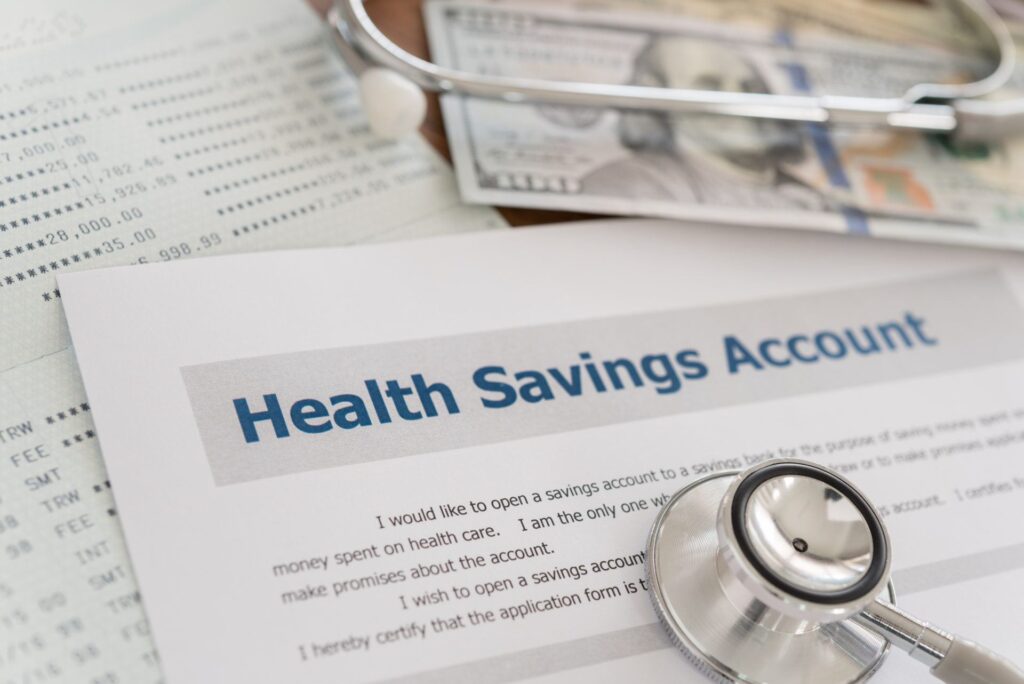 health savings account HSA contribution limits with application form,dollar money, stethoscope, bank account on desk.
