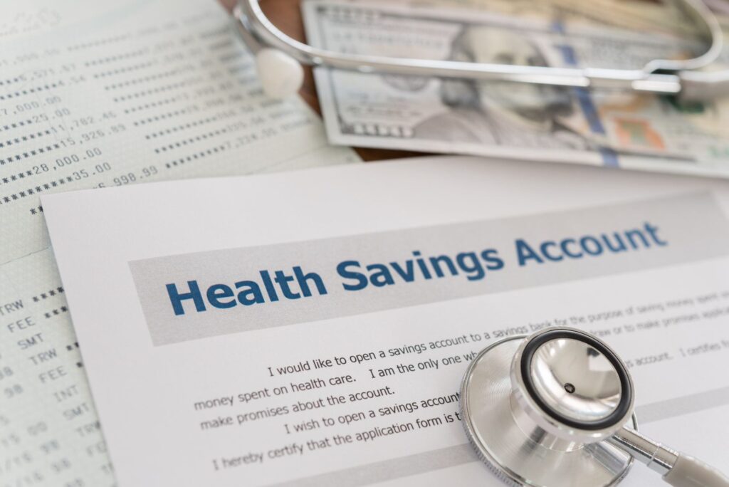 health savings account hsa contribution limits with application form,dollar money, stethoscope, bank account on desk.