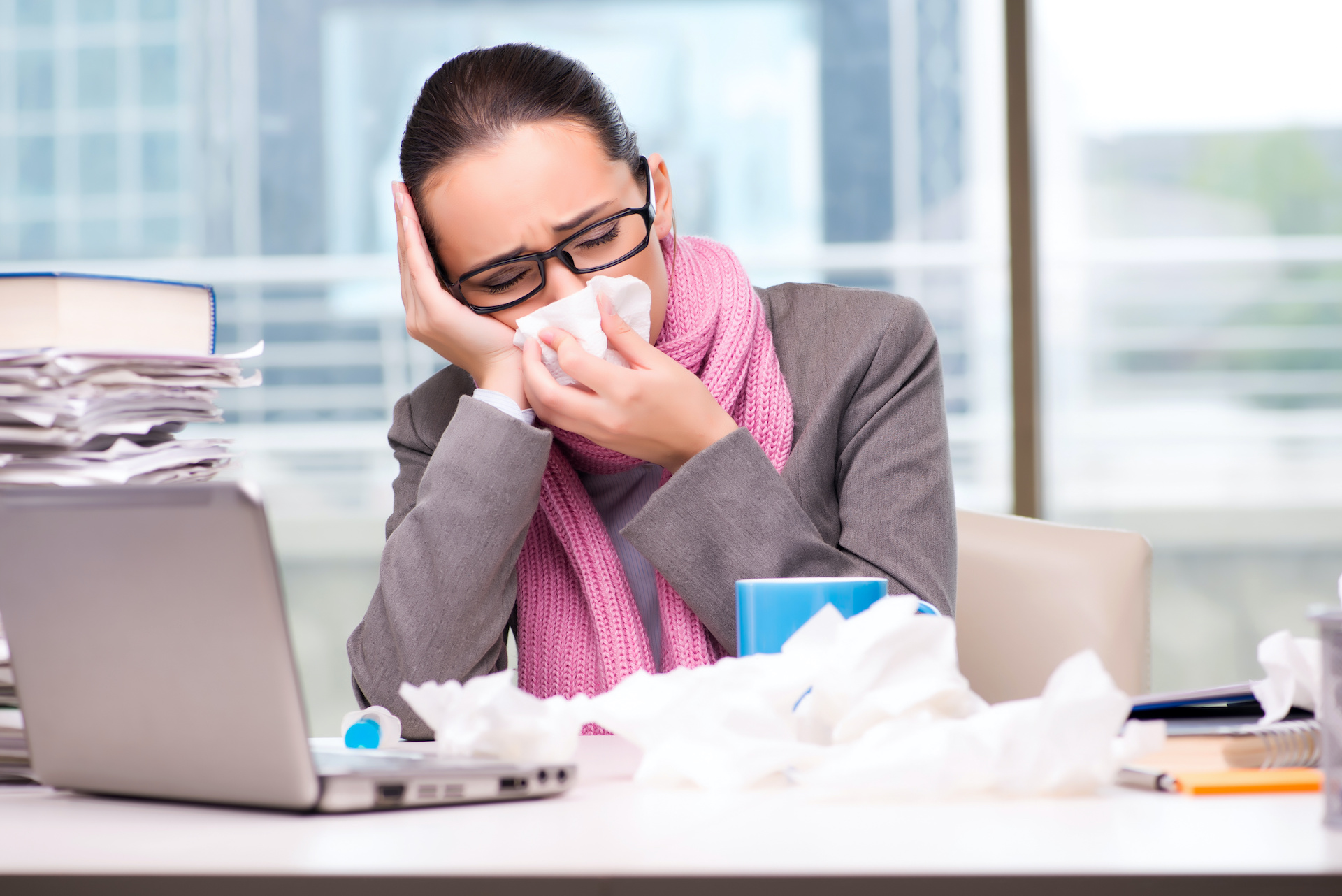 a woman sitting at a desk with her hands on her face