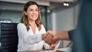 a woman shaking hands with a man in an office